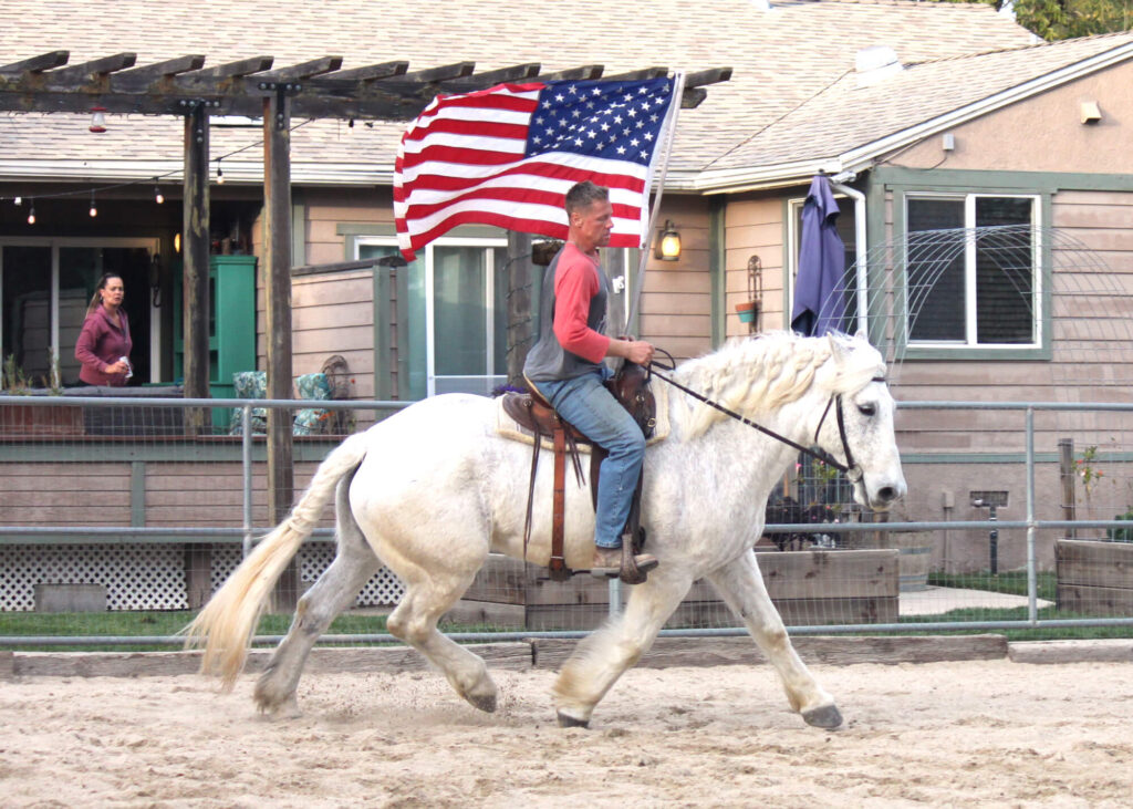 David Villalonga and Paulie parade flag riding